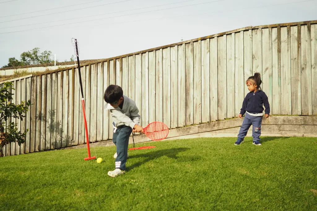 Children playing a racket game on the lawn