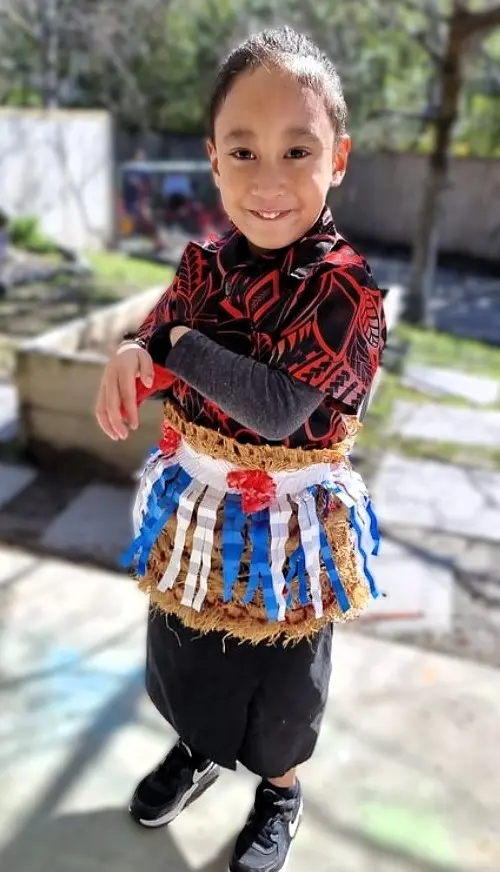 Child in cultural dress standing outdoors